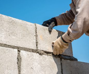 homeguide-masonry-contractor-laying-concrete-block-wall